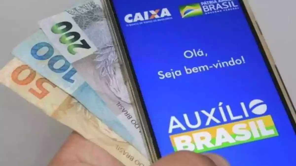 dinheiro e telefone aberto na pagina do auxilio brasil 1 374539