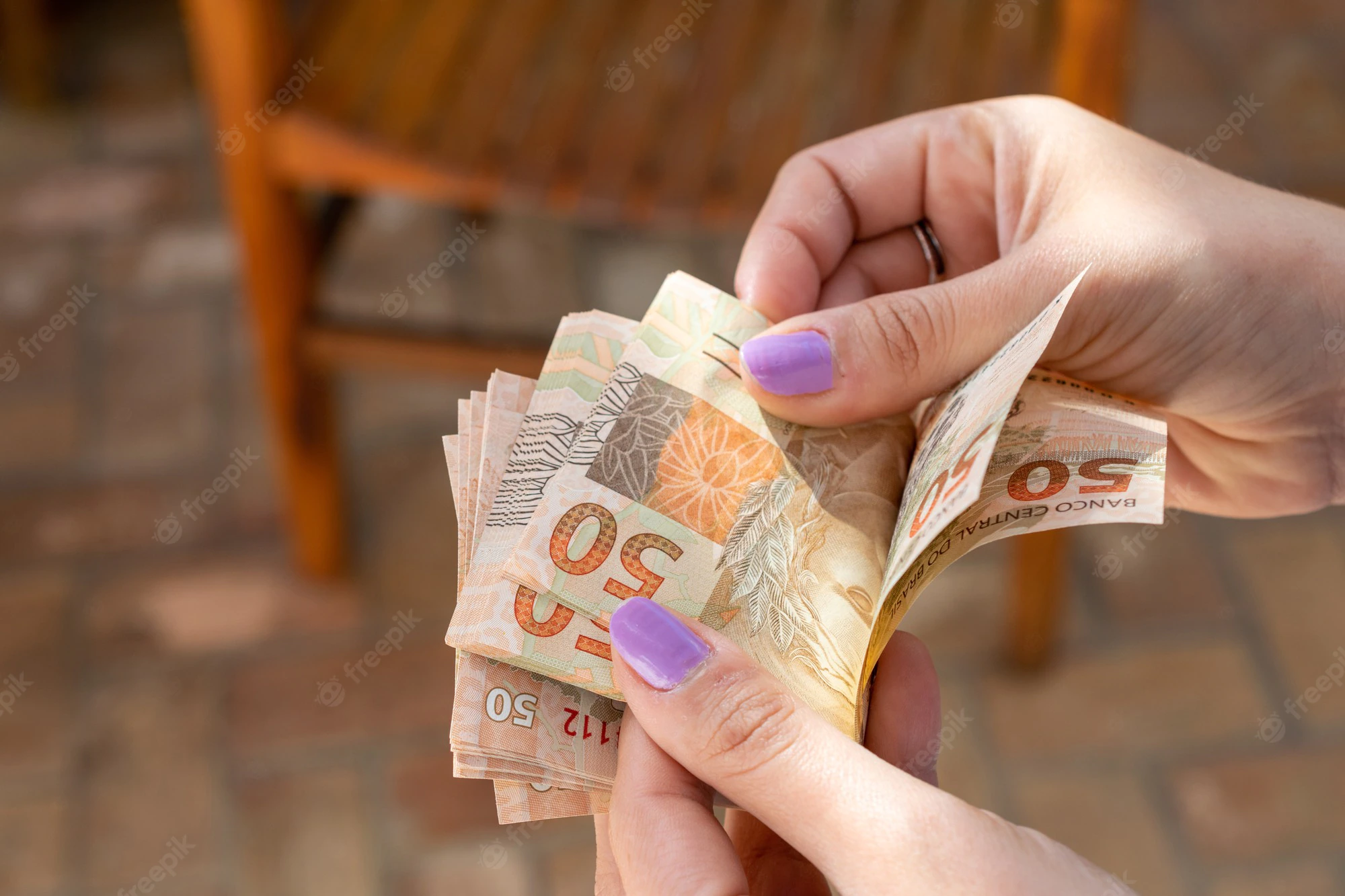 mao de mulher entregando cedulas de dinheiro brasileiro 146714 69